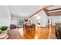 Bright dining room featuring wood floors, wood beams, and a large window for natural light at 7344 Woodglen Ct, Orlando, FL 32835