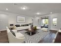 Modern living room featuring stylish decor, hardwood floors, and sliding glass doors to the patio at 7952 Wandering Way, Orlando, FL 32836