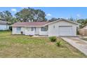 Charming single-story home featuring a well-maintained lawn, attached garage, and freshly painted exterior at 807 Vercelli St, Deltona, FL 32725