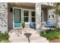 Inviting front porch with sleek columns, light gray walls, and comfortable blue chairs, perfect for relaxing at 8163 Upper Perse Cir, Orlando, FL 32827