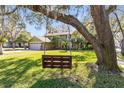 A charming home is viewed from under the branches of a large, mature tree with a wooden swing at 8413 Commander Cv, Winter Park, FL 32792