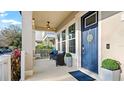 Inviting front porch featuring comfortable seating and a stylish blue front door at 9360 Meadow Hunt Way, Winter Garden, FL 34787