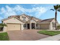 Beautifully landscaped home with a brick paver driveway and well-manicured lawn at 1191 Terralago Way, Kissimmee, FL 34746