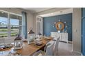 Coastal-themed dining room with a wooden table, decorative lanterns, and blue accent wall at 1336 Hanoverian Dr, Lake Alfred, FL 33850