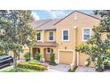 Charming two-story townhome featuring a tile roof, attached garage, and beautifully landscaped front yard at 1347 Benevolent St, Maitland, FL 32751