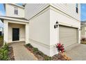 Home's entry with a black front door, beige walls, and dark lamp and some decorative foliage at 16207 Trinidad Way, Clermont, FL 34714