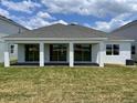 Spacious backyard featuring a covered patio with large sliding glass doors for seamless indoor-outdoor living at 16880 Muskgrass Dr, Winter Garden, FL 34787