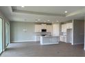 Open-concept living space with wood-look tile flooring, recessed lighting, and a view into the modern kitchen at 16880 Muskgrass Dr, Winter Garden, FL 34787