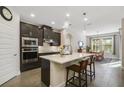 Modern kitchen featuring dark cabinets, stainless steel appliances, and a large island at 17858 Adrift Rd, Winter Garden, FL 34787