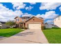 Two-story home boasts a spacious driveway, manicured lawn, and attached two-car garage, blending comfort and convenience at 1920 Partin Terrace Rd, Kissimmee, FL 34744