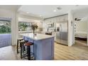 Bright kitchen with a marble countertop island, stainless steel appliances, and wood-look floors at 203 E Sweetwater Creek Dr, Longwood, FL 32779