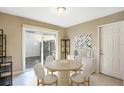 Bright dining area features neutral tones, a modern light fixture, and sliding glass doors to the back yard at 2811 Curry Woods Dr, Orlando, FL 32822