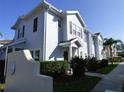 Townhouse exterior with light blue siding, dark shutters, and tidy landscaping along the sidewalk at 2903 Edenshire Way # 108, Kissimmee, FL 34746