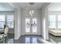 Bright foyer with decorative glass double doors and a modern chandelier at 352 Radisson Pl, Oviedo, FL 32765