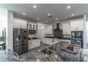 Modern kitchen featuring stainless steel appliances, white cabinets, and large granite countertops at 352 Radisson Pl, Oviedo, FL 32765