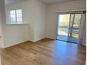 Bright living room featuring wood-look floors and sliding glass doors to balcony at 3701 Castle Pines Ln # 3923, Orlando, FL 32839