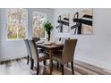 Bright dining room with wood-look floors, modern table set, and natural light from large windows at 505 St Johns Ct, Kissimmee, FL 34759