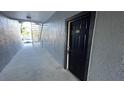 Exterior hallway leading to a unit featuring a black door with visible unit number against a gray building exterior at 5526 G Nw Ave # 4915, Orlando, FL 32815