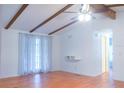 Bright living room featuring wood beams, a ceiling fan and wood flooring at 630 Carpenter Rd, Orlando, FL 32833