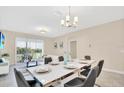 Bright dining room featuring a modern table setting, chandelier, and sliding glass doors to an outdoor patio at 635 Ocean Course Ave # 635, Champions Gate, FL 33896