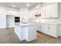 Bright, spacious kitchen featuring white cabinets, stainless steel appliances, an island, and wood flooring at 652 Kimber Ln, Debary, FL 32713