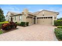 Spacious garage with a brick paved driveway and lush landscaping at 8774 Bayview Crossing Dr, Winter Garden, FL 34787