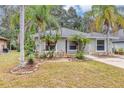 Charming single-story home with a well-manicured lawn and mature palm trees creating curb appeal at 912 Enterprise Ave, New Smyrna Beach, FL 32168