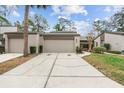 Inviting townhome showcasing an attached garage, clean driveway, and manicured front yard at 95 Carolwood Blvd, Fern Park, FL 32730