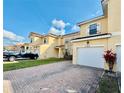 Inviting townhome featuring a red brick driveway, well-maintained lawn, and a one car garage at 1183 Chervil Dr, Poinciana, FL 34759