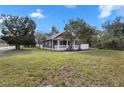 Charming home featuring a covered porch, mature trees, and a well-maintained lawn at 202 Division, Deland, FL 32720