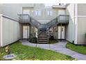 Condo exterior featuring dual staircases leading to upper units, surrounded by green space at 282 Scottsdale Sq # 282, Winter Park, FL 32792