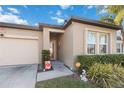 Inviting front entrance with manicured bushes, trimmed green grass and a cream-colored exterior at 2857 Neverland Dr, New Smyrna Beach, FL 32168