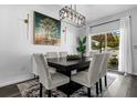 Dining area with a modern chandelier, large art piece and a view of the screened-in porch at 4860 Osprey Way, Winter Haven, FL 33881