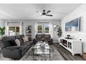 Comfortable living room with gray couches, white decorative wall, and a ceiling fan at 4860 Osprey Way, Winter Haven, FL 33881