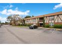 Wide view of condo exterior displays Tudor accents, brick facade, landscaping, and parking at 5405 Hansel Ave # G9, Orlando, FL 32809