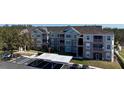 Exterior view showcasing the building's architecture, balconies, covered parking, and well-maintained landscaping at 583 Brantley Terrace Way # 303, Altamonte Springs, FL 32714