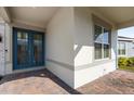 Charming entryway with brick paving, blue double doors, and a large window at 8309 Park Cliff Way, Orlando, FL 32836