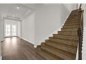 Elegant staircase with mosaic tile accents and hardwood floors at 8309 Park Cliff Way, Orlando, FL 32836