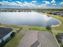 Stunning aerial view of a home backing onto a serene lake with lush greenery and neighboring houses at 113 Azure Mist Way, Daytona Beach, FL 32124