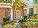 Charming front door with decorative wreath, sidelights, and stone pillar accents at 1144 Legg Dr, Apopka, FL 32712