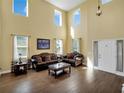 Bright living room featuring soaring ceilings, wood floors, and comfortable seating at 1144 Legg Dr, Apopka, FL 32712