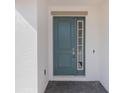Inviting front door with side window, set in a white wall with gray pavers at 1260 Tupelo Trl, Haines City, FL 33844