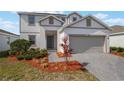 Charming two-story home featuring a well-maintained front yard and gray brick driveway at 1260 Tupelo Trl, Haines City, FL 33844