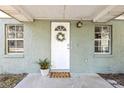 Welcoming front entrance featuring a decorative wreath and a stylish welcome mat, creating a warm and inviting first impression at 1744 E Welch Rd, Apopka, FL 32712