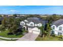 Aerial view of a spacious home with a brick driveway, three-car garage, and lush landscaping at 1910 Lake Roberts Landing Dr, Winter Garden, FL 34787