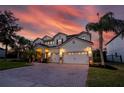 Elegant two-story home displaying a three-car garage and an inviting, warmly lit front entrance at 1910 Lake Roberts Landing Dr, Winter Garden, FL 34787