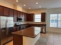 Open kitchen features dark wood cabinets, granite countertops and stainless steel appliances at 2205 W Lobelia Dr, Lake Mary, FL 32746