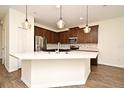 Modern kitchen features stainless steel appliances, a spacious island, and stylish pendant lighting at 2659 Magpie Way, Sanford, FL 32773