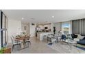 Open floor plan with kitchen island, dining space, and stylish living area at 2999 Brie Hammock Bnd, St Cloud, FL 34773