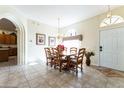 Inviting dining room featuring an arched doorway, tile flooring, and a wooden table with seating for six at 305 Grand Reserve Dr, Davenport, FL 33837